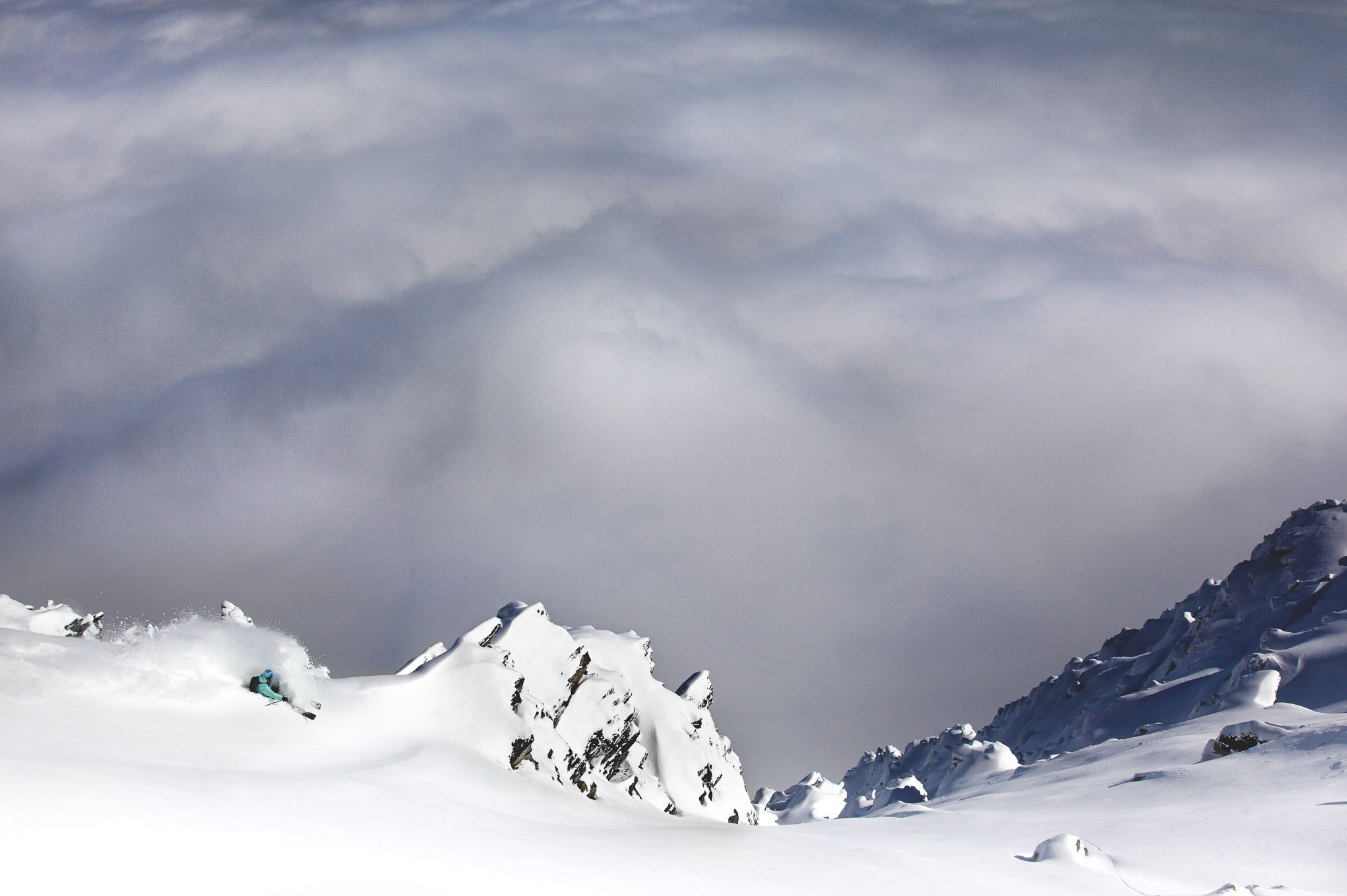 Free Skier Pete Oswald Skiing powder above clouds up The Remarkables