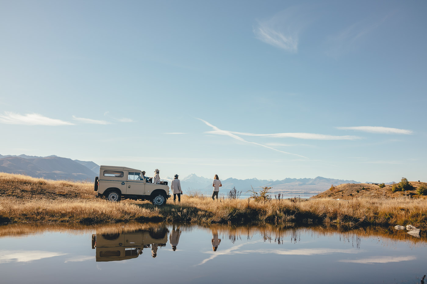 Friends sitting on the Land Rover enjoying the views over Lake Pukaki