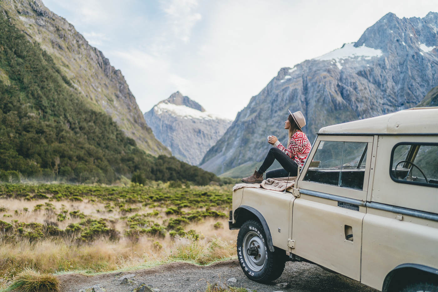 Enjoying a hot drink on a vintage Land rover in Fiordland, New Zealand