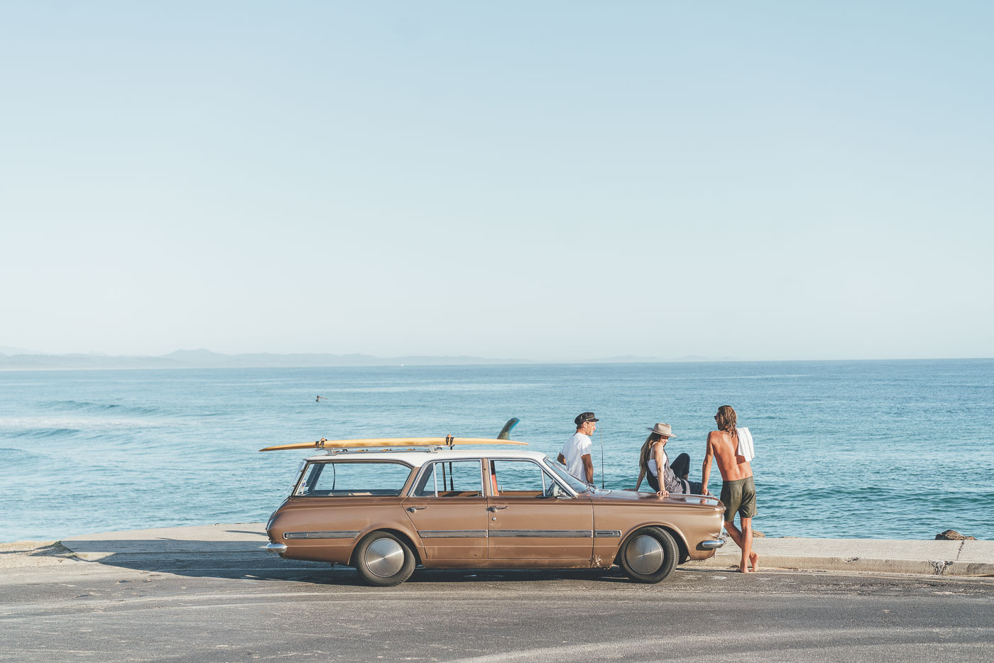 Friends hanging out at Byron bay with vintage car