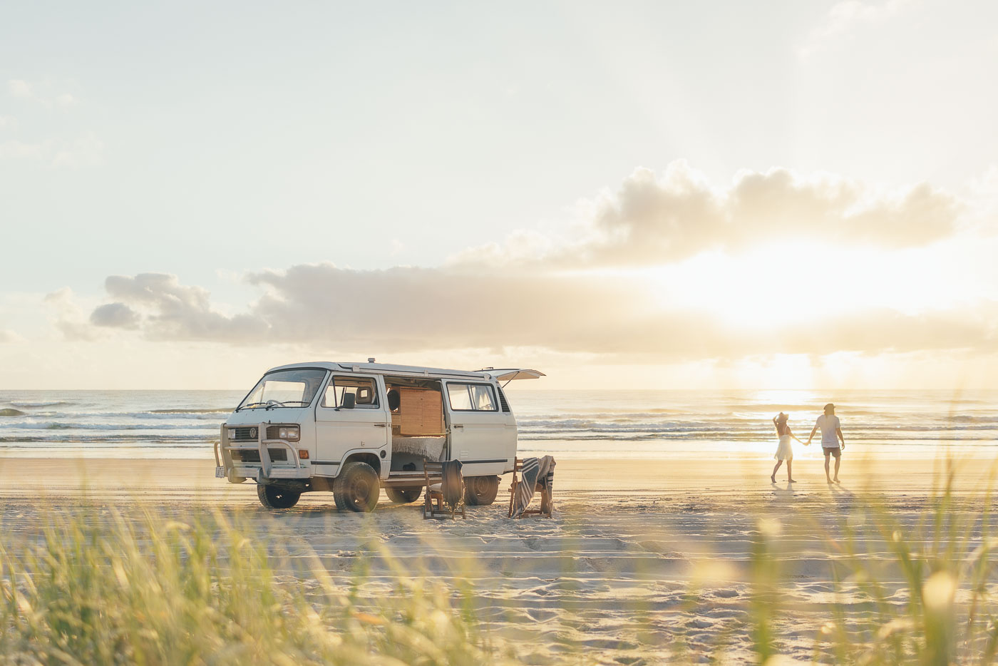 Couple parked on the beach going for a walk at sunrise