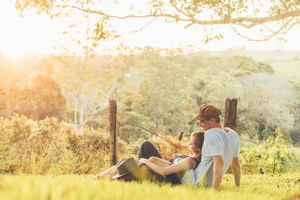 Couple in grass at sunset