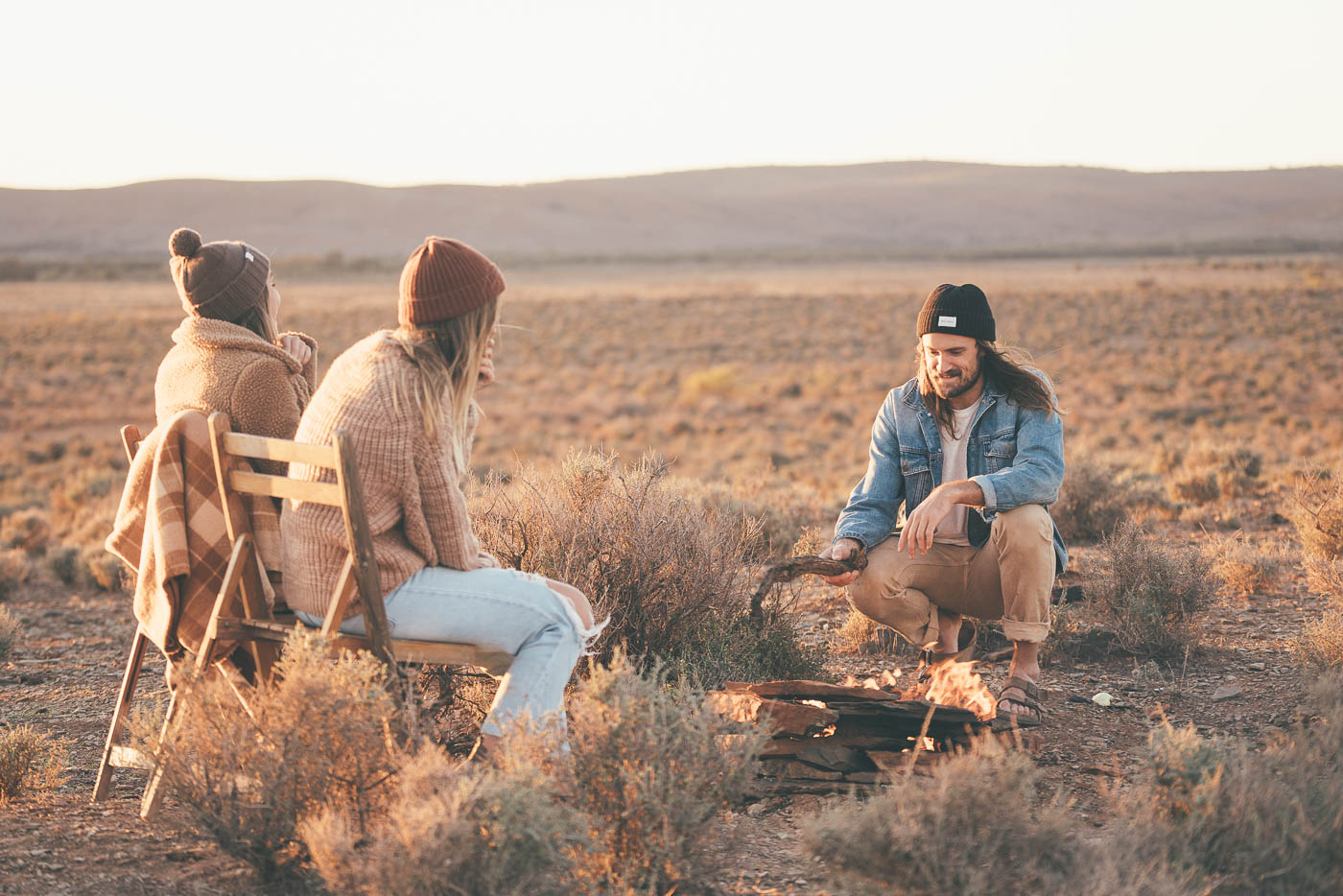 Will and Bear friends hanging around a campfire in South Australia Desert. Captured by Adventure Photographer Stefan Haworth