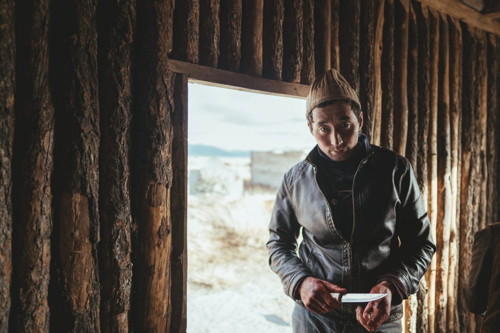 Portrait of Mongolian farmer holding knife in Mongolia. Captured by adventure photographer Stefan Haworth