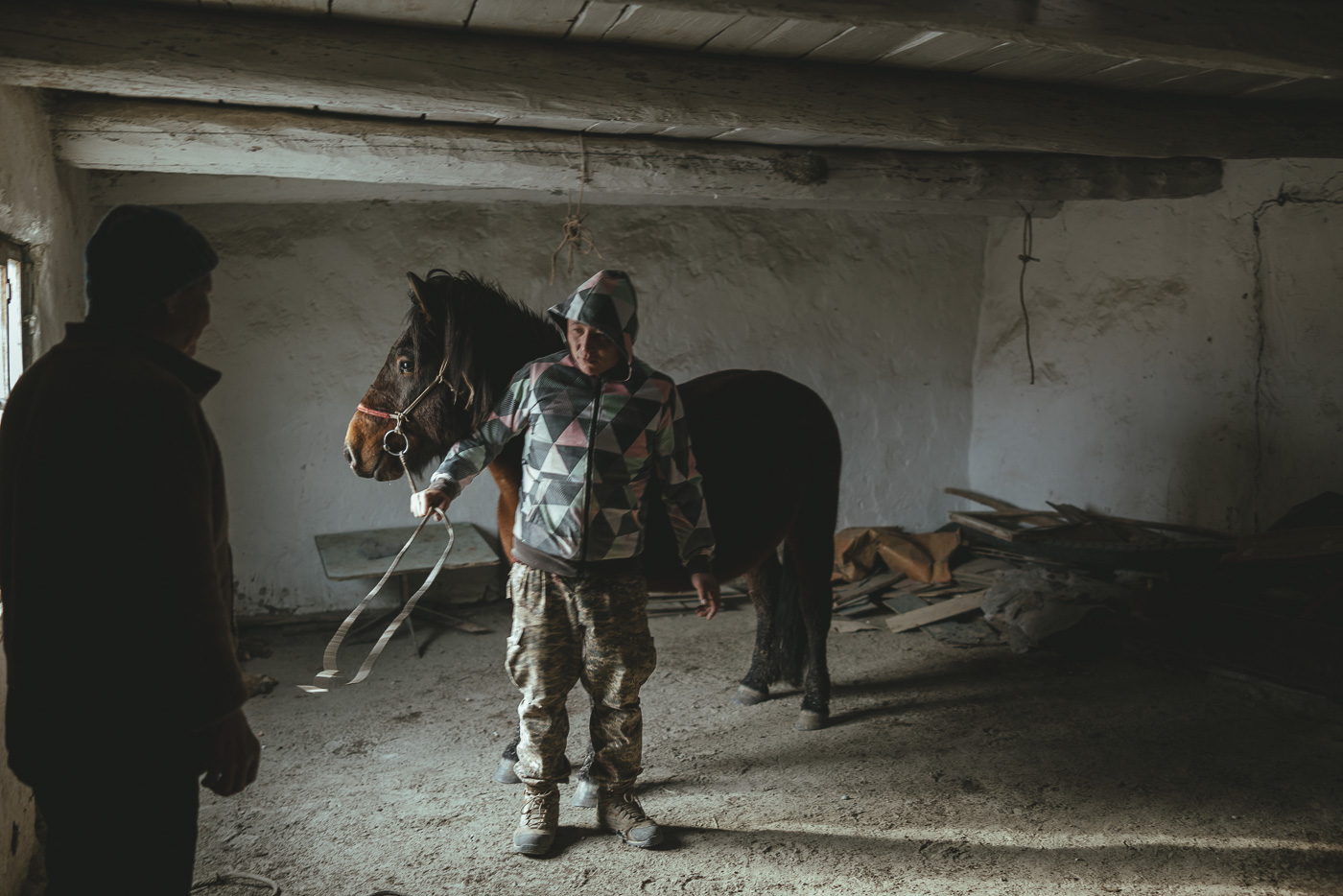 Mongolian farmer indoors preparing a horse for the winter meat harvest in western Mongolia. Captured by adventure photographer Stefan Haworth