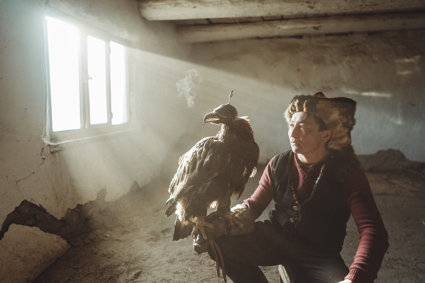 Eagle on Kazakh Eagle hunters arm with light rays through the dust. Captured by Sony Ambassador and adventure photographer Stefan Haworth