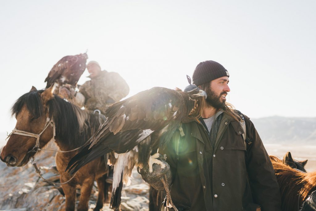 Adventure Photographer Stefan Haworth hunting with the eagle with the other Kazakh Eagle Hunters out in Western Mongolian Mountains.