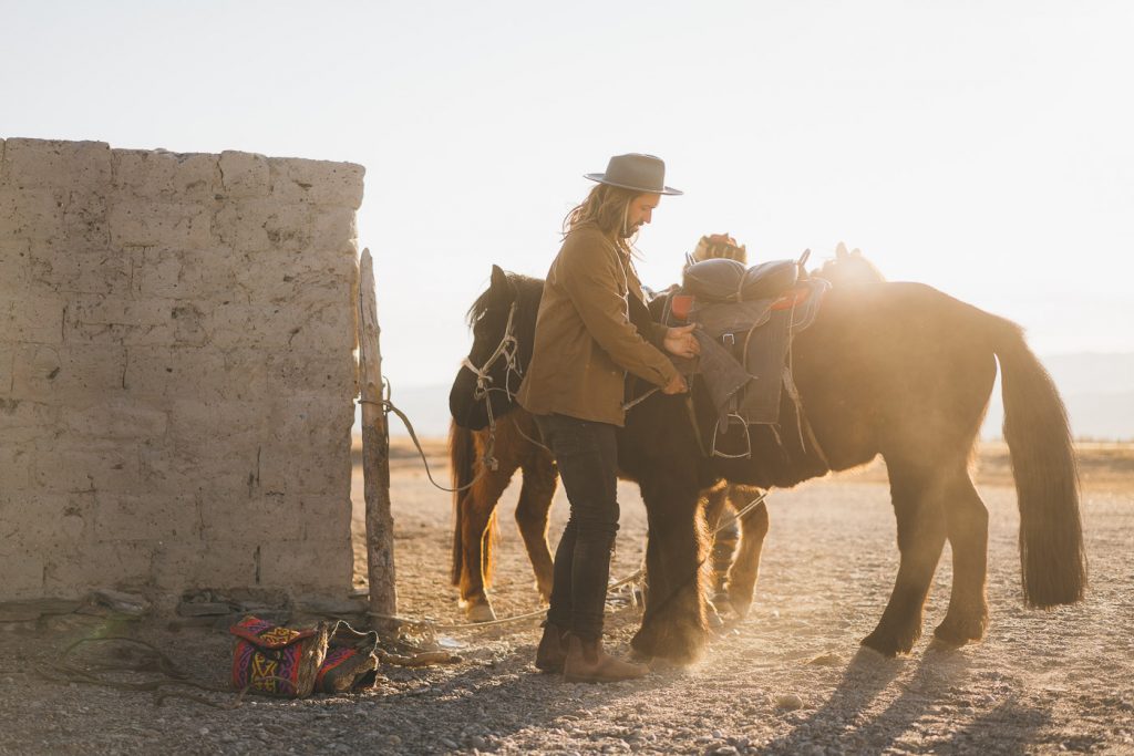 Adventure Photographer Stefan Haworth preparing the horse for a ride out in Western Mongolian Mountains.