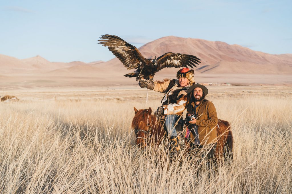 Adventure photographer Stefan Haworth and Kazakh eagle hunter on horseback in the western Mongolian mountains.