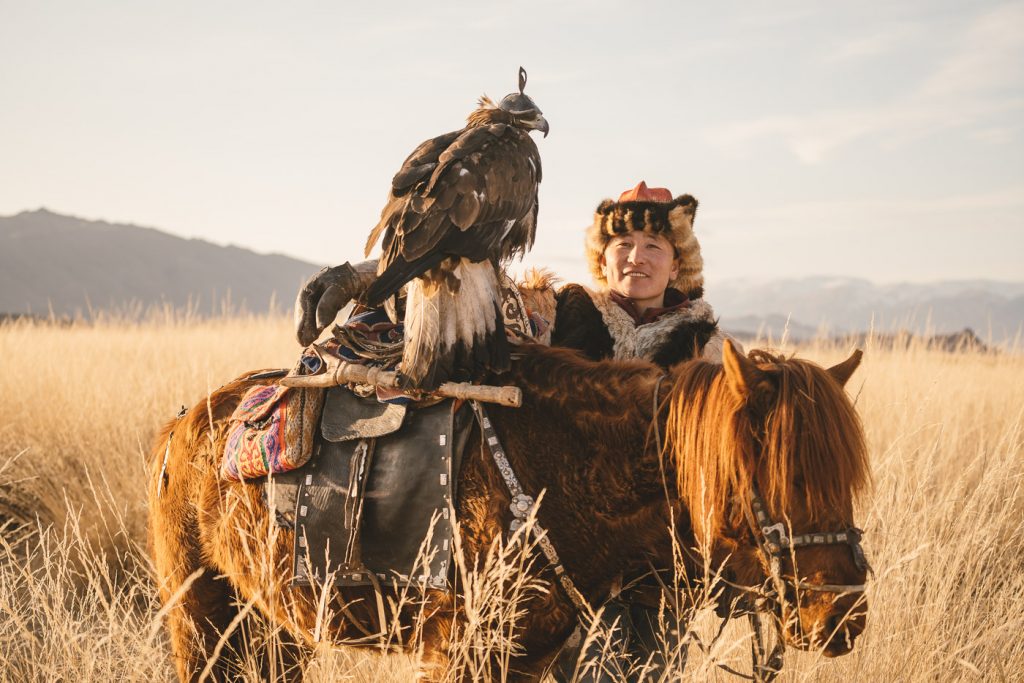 Kazakh Eagle Hunter on horseback at sunset in the mountains of western Mongolia. Captured by adventure photographer Stefan Haworth