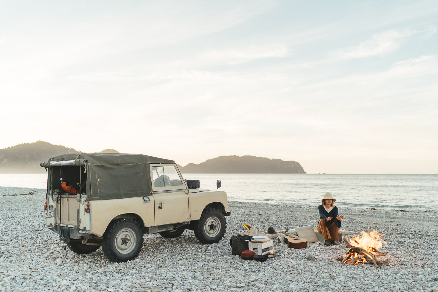 Jade Barclay watching the bonfire next to the Series Land rover in Haast on the west coast of new Zealand. Captured by Sony Ambassador and Photographer Stefan Haworth