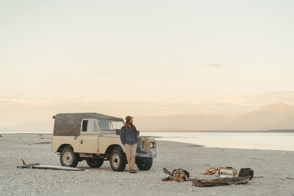 Stefan Haworth watching the Campfire next to the Series Land rover in Haast on the west coast of new Zealand.