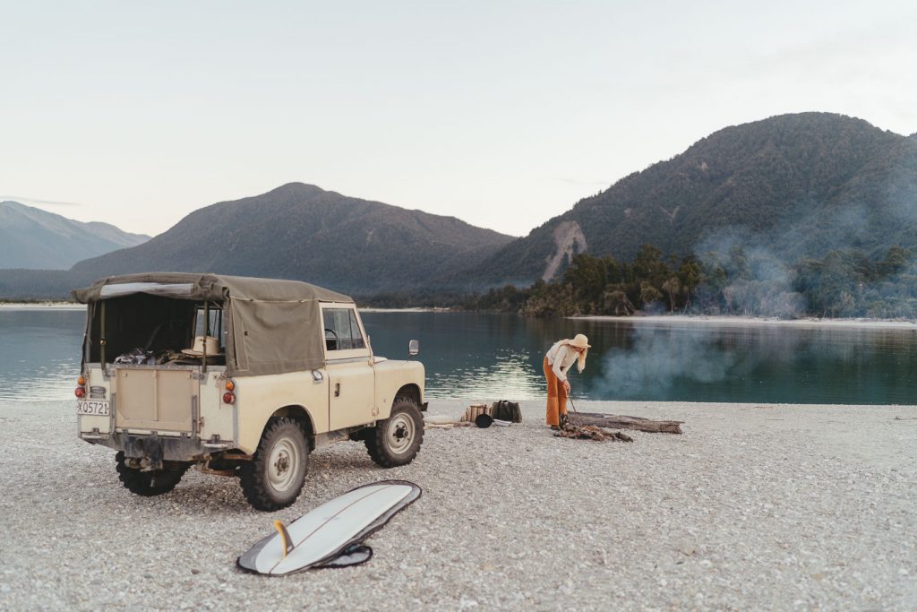 Jade Barclay watching the bonfire next to the Series Land rover in Haast on the west coast of new Zealand. Captured by Sony Ambassador and Photographer Stefan Haworth