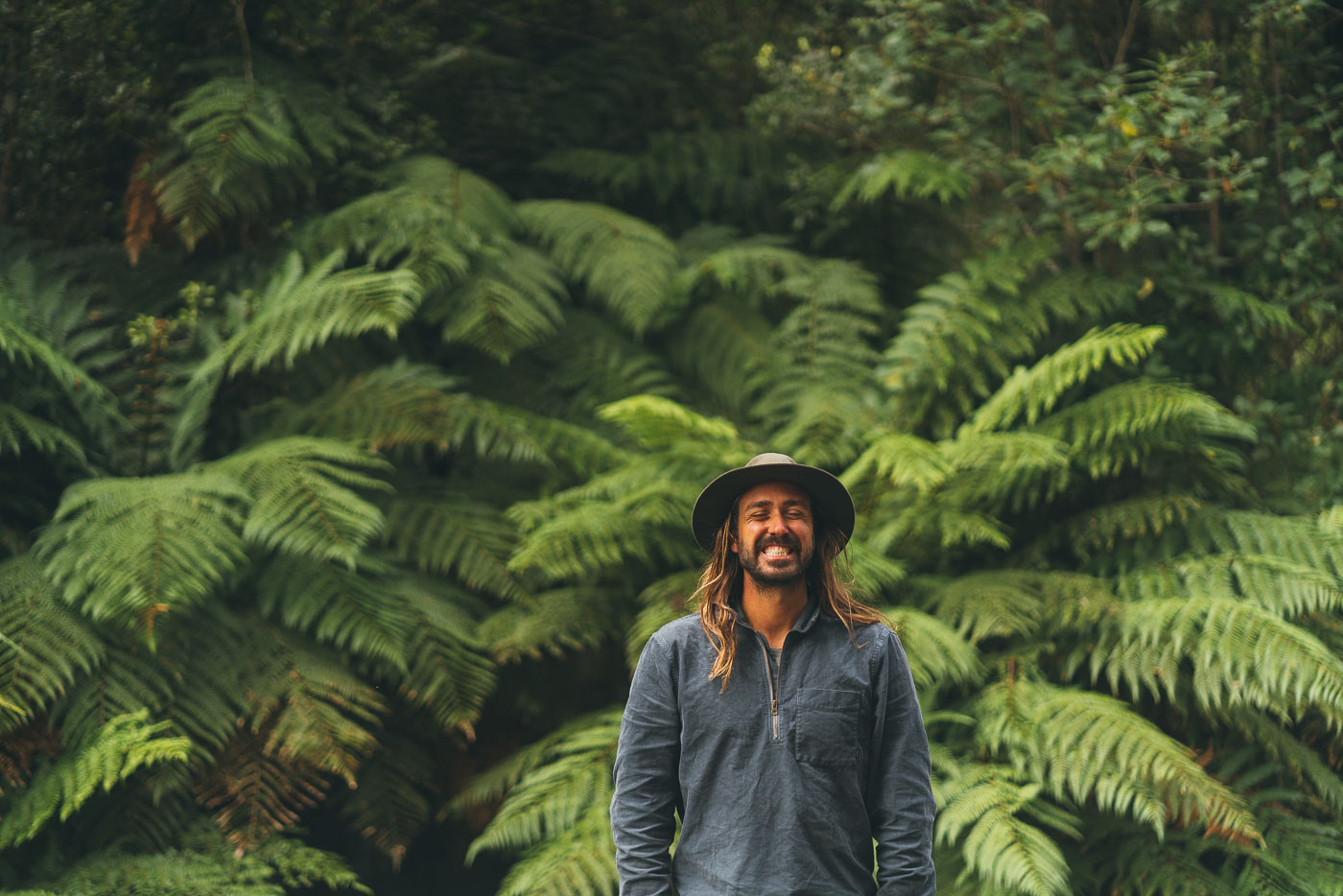 Portrait of adventure Photographer Stefan Haworth with the Background of green ferns of the West Coast of New Zealand