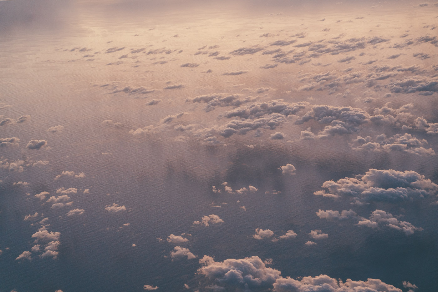 Sunset clouds over the ocean while flying with Air New Zealand