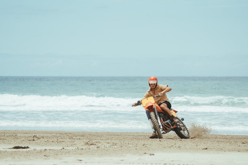 Jonty riding up the beach on the vintage motorbike. Captured by Adventure photographer Stefan Haworth