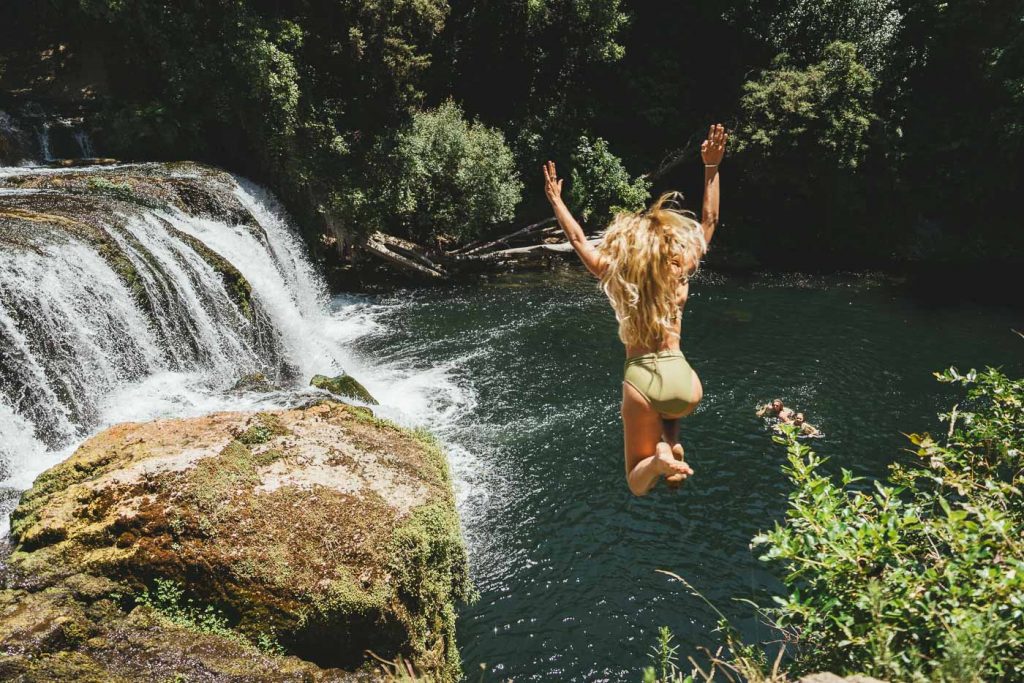 Jade Barclay jumping off the local havelock North waterfall during a break from Nestfest 2022 during a Roadtrip of New Zealand's east Cape. Captured by Photographer Stefan Haworth