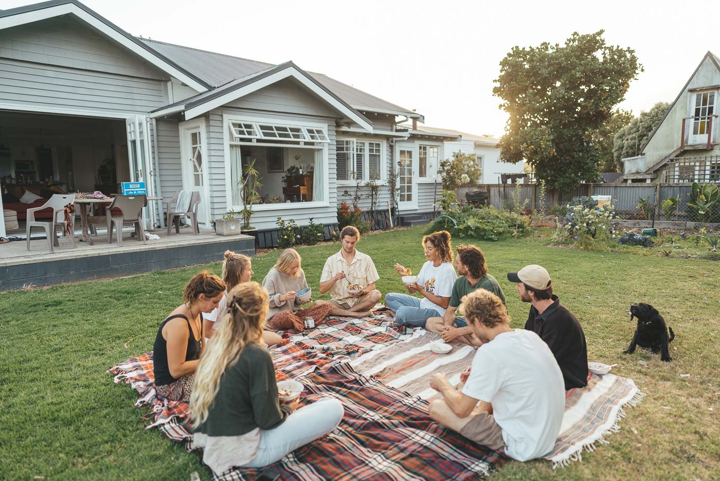 Dinner on Ellen Taylor and Tiago Kerber front lawn at Wainui Beach on the East Cape Road trip of New Zealand. Captured by Adventure photographer Stefan Haworth