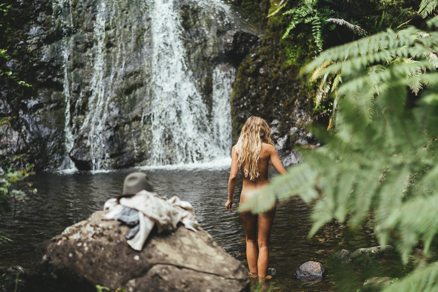 Jade in nature under a waterfall surrounded by forests on the East cape of New Zealand