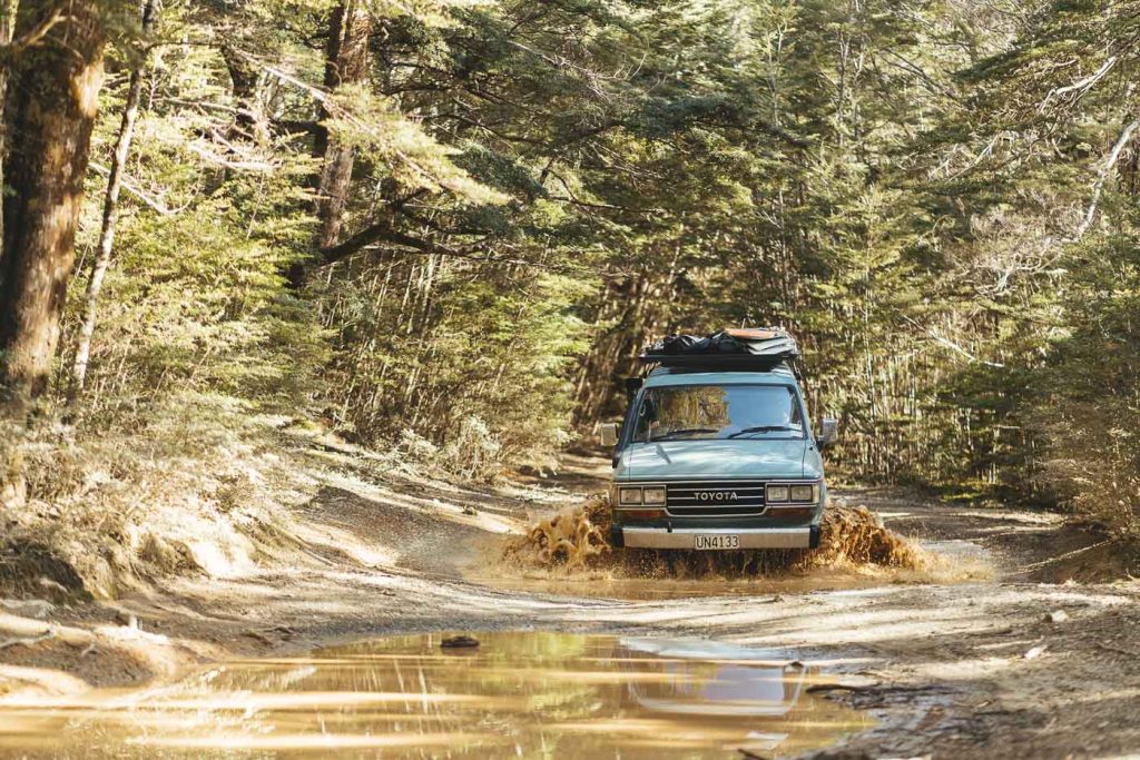 Joe Leeper 4wding the vintage Land cruiser through mud in remote New Zealand backcountry. Captured by Stefan Haworth