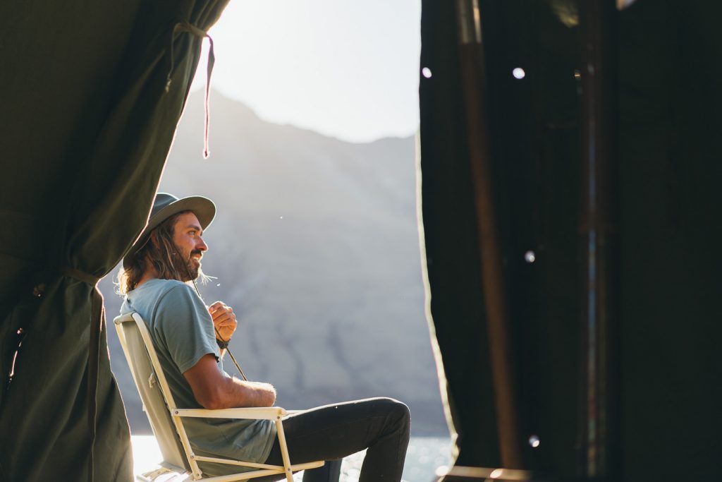 Photographer Stefan Haworth relaxing next to a remote lake of New Zealand's Southern Alps