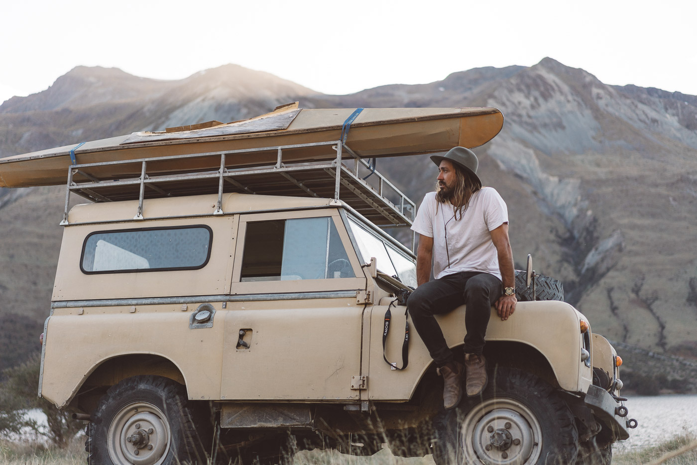 Adventure Photographer Stefan Haworth relaxing on the Vintage Series Land Rover in the Souther Alps of New Zealand