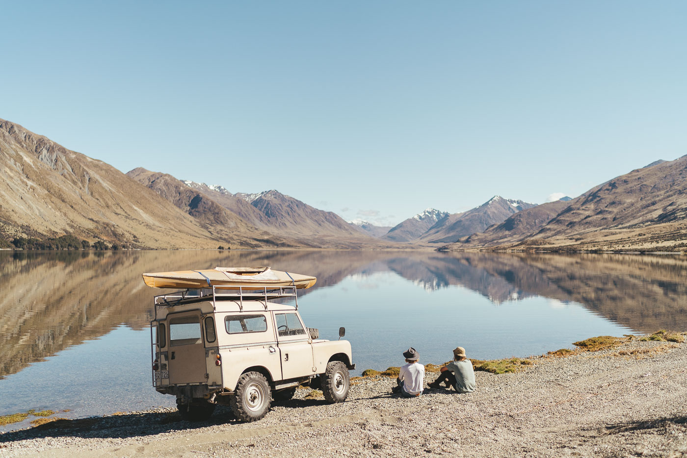 Photographer Stefan Haworth and Joe Leeper lakeside with series land Rover in Southern Alps of New Zealand. Captured by Photographer Stefan Haworth.