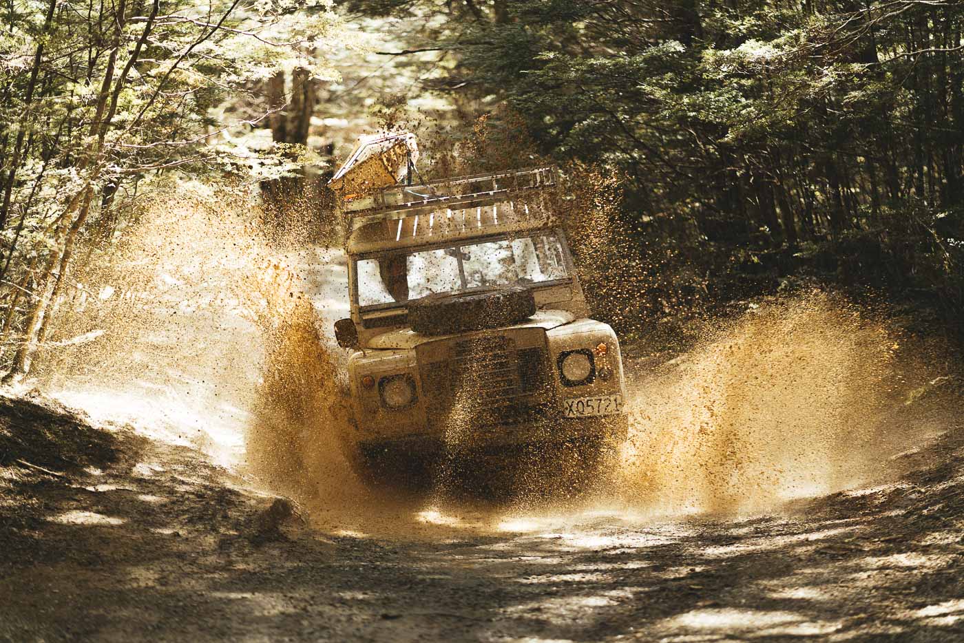 Adventure Photographer Stefan Haworth 4wding the vintage series Land rover through mud in remote New Zealand backcountry