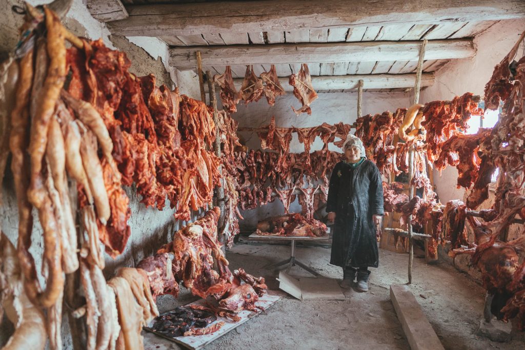 Kazakh Mother filling the freezer room with thier meat for the hard Mongolian winter