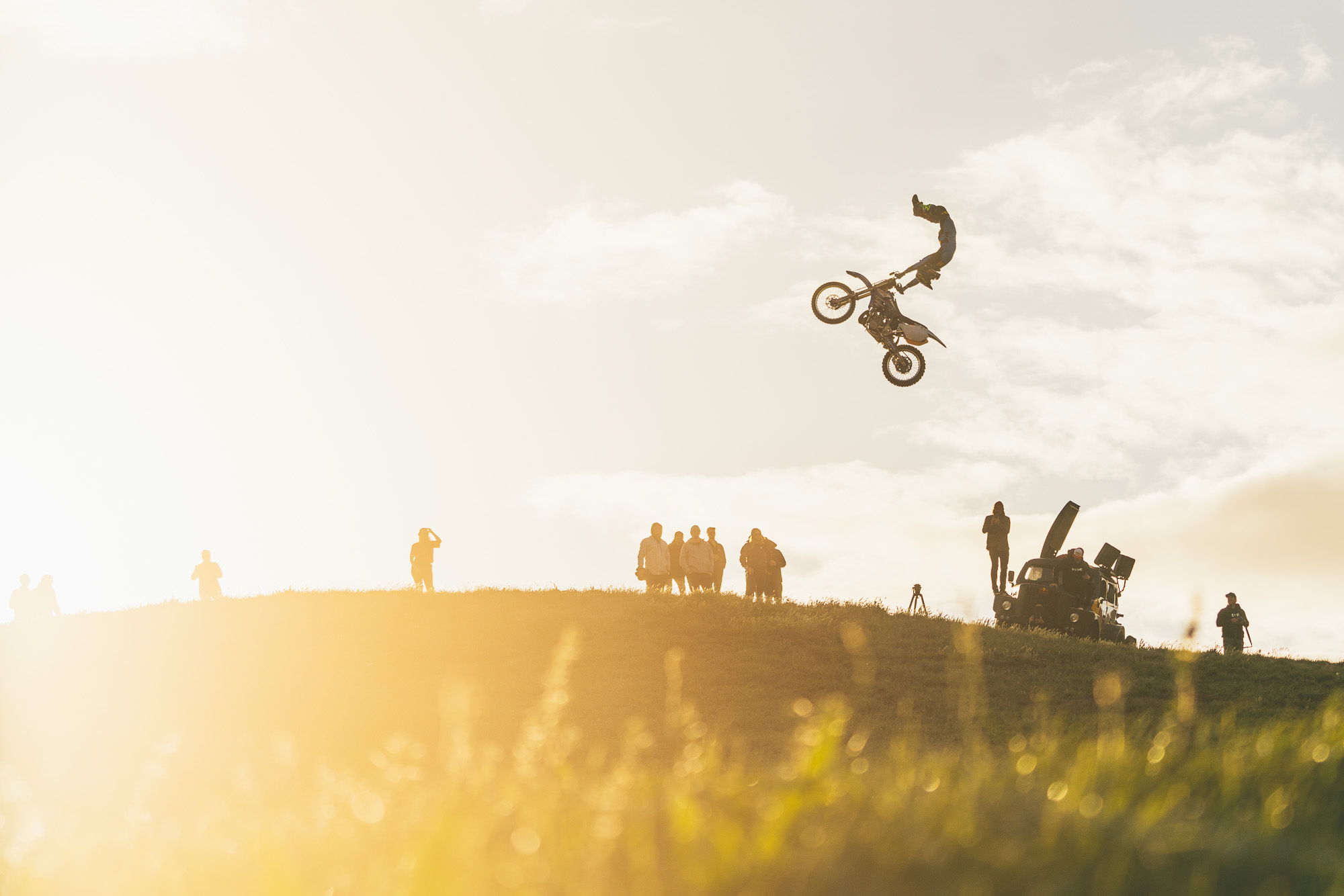 Redbull athlete and FMX rider Tyler Bereman hitting big jump at the frew farm jam in sunset light in New Zealand