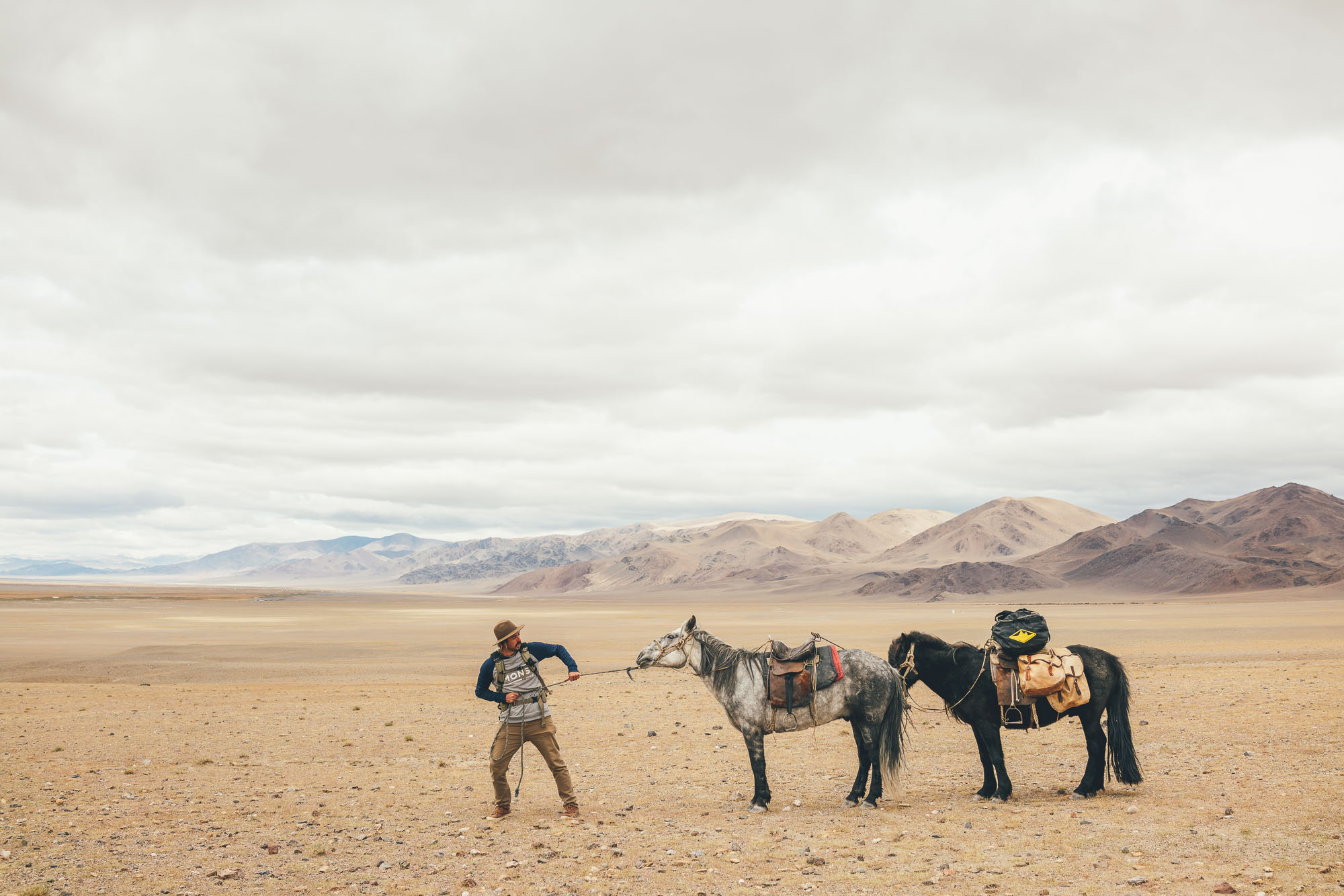 Photographer Stefan haworth pulling two horses in Ulgii Mongolia