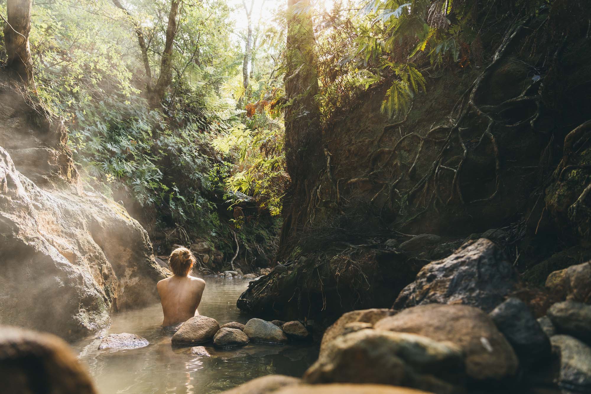 Jade sitting natural thermal hot pools in Great Barrier Island in New Zealand.