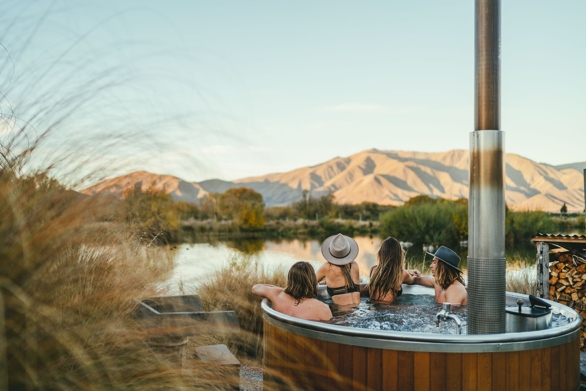 Will and Bear crew sitting in Omarama hot pools at sunset on a NZ road trip to Mount Cook