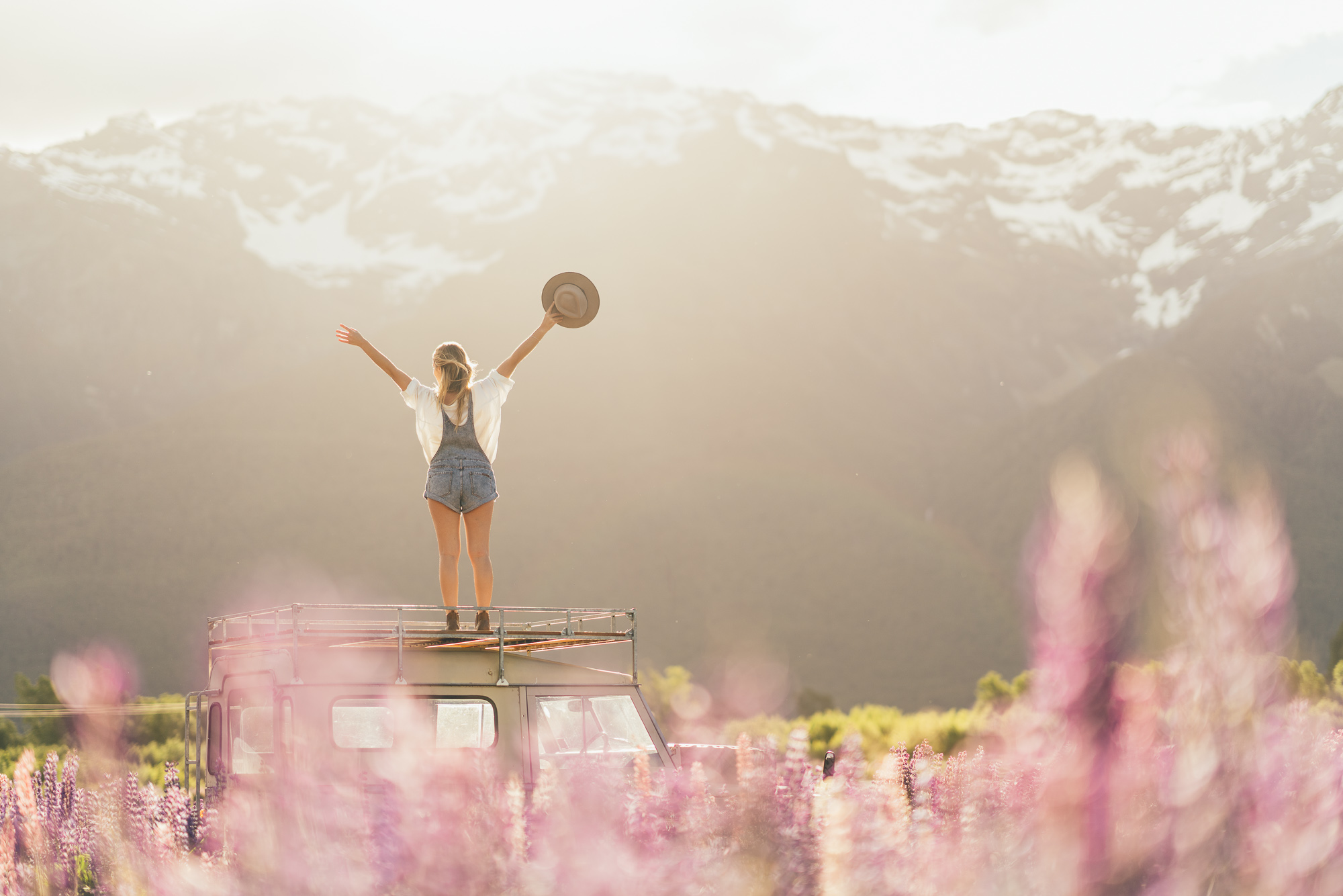 Jess Standing on Land rover in Glenorchy with Lupins, New Zealand