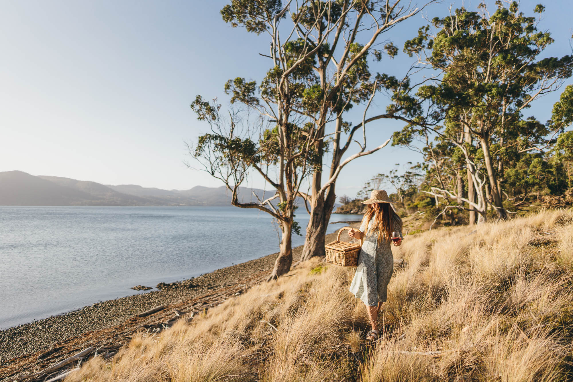 Outdoor Chef Sarah Glover walking with picnic basket at SheepwaStefan_haworth_commercial_photographer_Outdoor Chef Sarah Glover walking with picnic basket at Sheepwash Bay on Bruny Island, Australia_04123sh Bay on Bruny Island, Australia